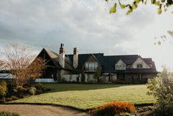 Wide view of the Chateau de Lis manor and grounds beneath a stormy sky