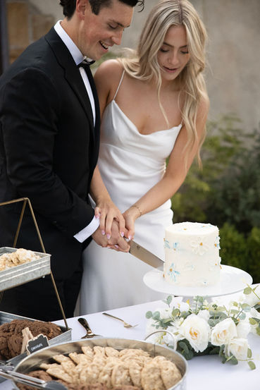Bride and groom cutting their wedding cake together