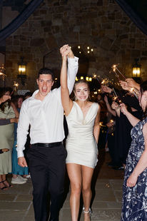 Newlyweds raising joined hands beneath a shower of sparklers